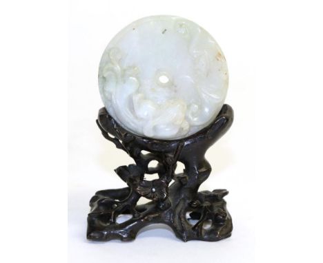 A Jade Disc Pendant, carved with a bat and kylin, the reverse with seal marks, 5cm diameter, wooden standVery minor surface a