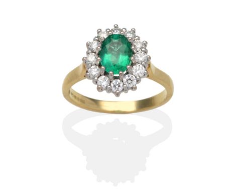 An 18 Carat Gold Emerald and Diamond Cluster Ring, an oval cut emerald within a border of round brilliant cut diamonds in whi