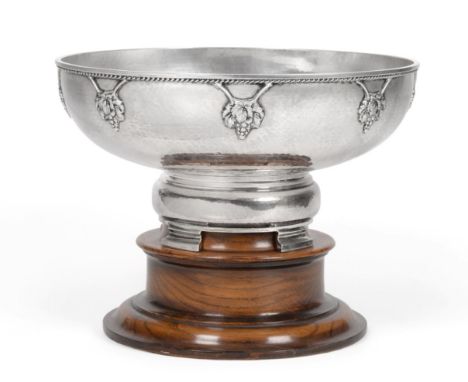 An Arts & Crafts Silver Bowl, M Beaver Ltd, Birmingham 1929, with hammered finish, the rim decorated with fruiting vines and 