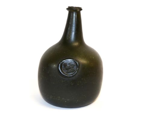 A Green Glass Sealed Wine Bottle, 18th century, of onion shape, the seal with a lion passant, 19cm highLosses to string ring.