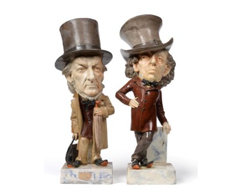 A Pair of Pottery Caricature Figures of Gladstone and Disraeli, late 19th century, both modelled standing, Gladstone holding 