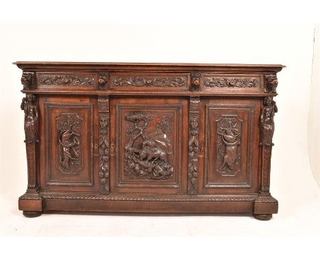 A large Victorian oak Jacobethan style sideboard, standing on four turned feet with three panelled doors to front and three d