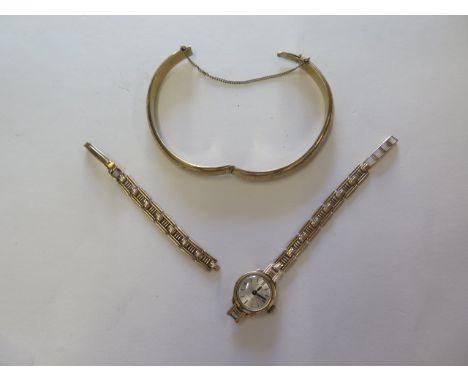 An 8ct gold bangle marked 333, slight damage approx 13grams, a 9ct gold watch with broken strap, weight approx 9.4grams, not 