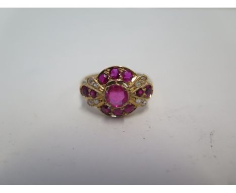 An unhallmarked ruby and diamond cluster ring, size S, approx 5.4grams, tests to approx 18ct, please note rubies have not bee