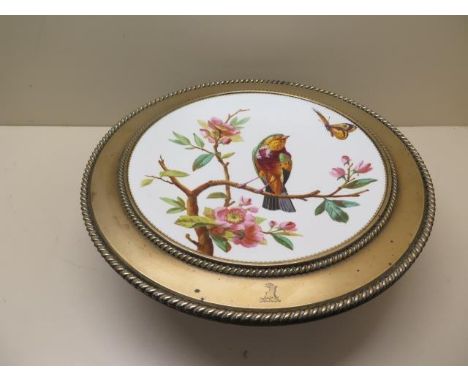 A 19th century bird decorated bronze and porcelain tazza with a crest, 10cm tall x 33cm diameter with some usage wear, genera