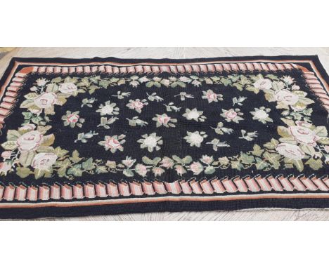 A late 20th century black ground tapestry rug 
