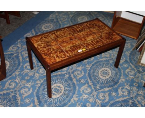 A teak rectangular coffee table the top inset with brown and green glazed ceramic tiles 40 cm x 86 cm x 50 cm