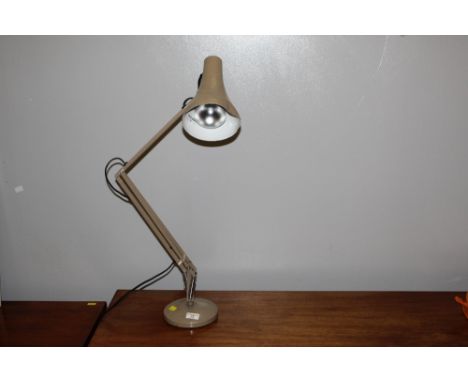 A light brown metal anglepoise style desk lamp. 