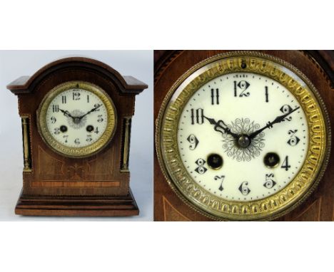 A 1920s walnut mantel clock with inlaid wood panels, dome top and brass columns, the cream enamel and painted dial set with A