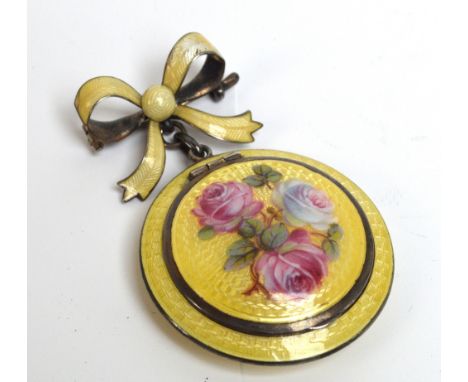 A George V hallmarked silver and yellow enamel decorated powder/patch box of circular form with bow pinned brooch suspending 