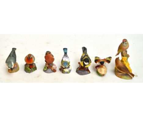 Seven Royal Worcester matt glazed figures of birds; "Chaffinch", "Gold Finch", "Great Tit", "Nut Hatch", "Robin", "Linnet" an
