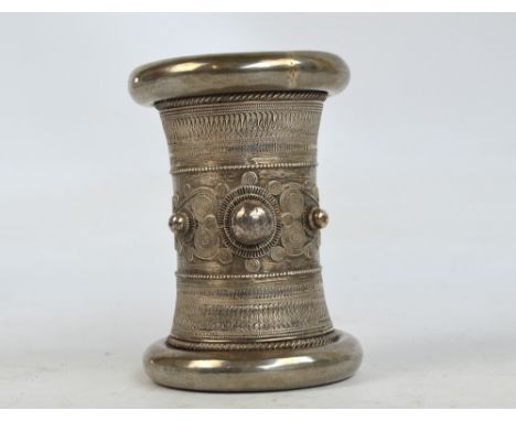An early 20th century Indian white metal wedding bangle, with applied filigree decoration, centred with a large boss flanked 