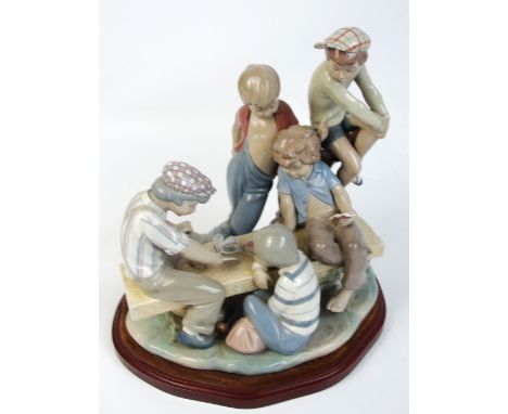 A large Nao figure of young boys playing cards, mounted on a shaped plinth, height 35cm.