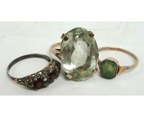 A 9ct gold dress ring with large oval pale green stone, a yellow metal dress ring, and a further dress ring (3).