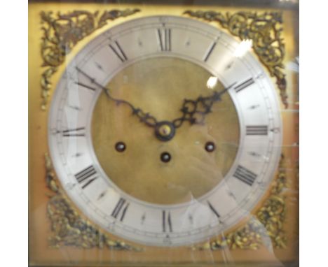 A 1920's oak longcase clock with eight day movement, the carved arched dial above square brass dial with silvered chapter rin