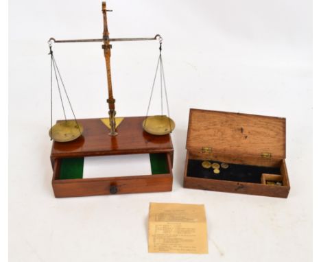 A set of late 19th century beam scales set on a mahogany stand containing a small drawer, the scales remove from the stand an