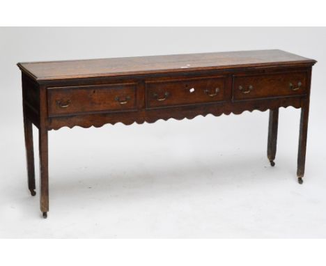 A Georgian oak and mahogany banded dresser base, with three frieze drawers above a fretwork apron, raised on square section s