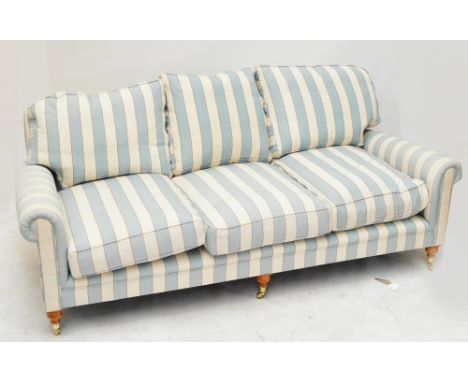 A contemporary blue and cream striped upholstered three seater settee raised on ring turned front legs to brass caps and cast