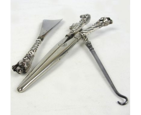 A pair of Victorian hallmarked silver handled glove stretchers, the finials modelled as lion heads, a matching shoe horn, and
