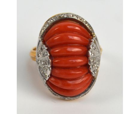 An 18ct gold Art Deco style ring with central ribbed coral coloured band within a boarder of diamonds, set in a pierced scrol