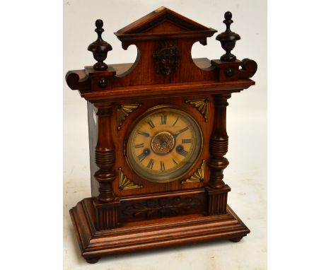 A c.1900 German walnut and beech mantel clock with arched pediment and circular dial set with Roman numerals, height 42cm.