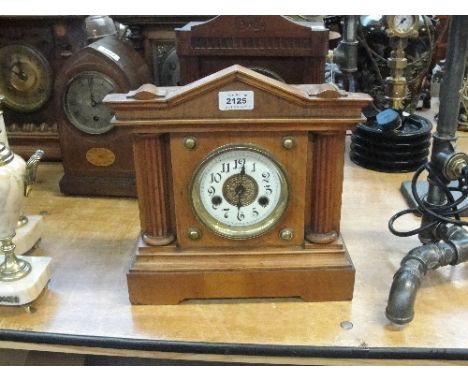A German walnut and stained beech mantel clock with circular dial set with Arabic numerals flanked by fluted pilasters, width