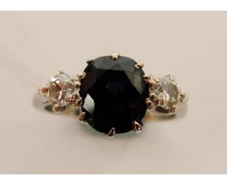 An 18ct white gold ring, set with sapphire flanked by two diamonds, approx 0.12cts, size K.