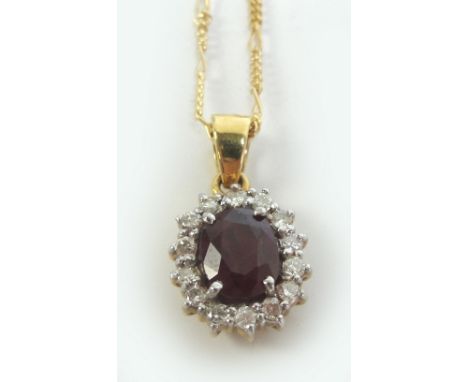 An 18ct gold ruby and diamond oval pendant suspended on an 18ct gold fine link chain.