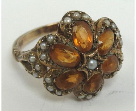 A 9ct gold floral set dress ring with central panel of six orange coloured stones within a border of seed cultured pearls, si