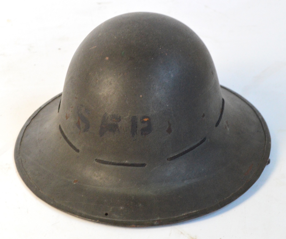 A WWII period tin helmet stamped "A.M.C. 1941".