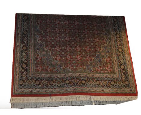 A Hamadan rug with three central conjoined lozenge shaped medallions within a device set main panel and stylised border, over