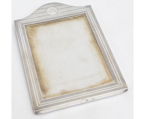 A George V hallmarked silver arched rectangular photograph frame with engine turned decoration and inscription "To Nellie & J