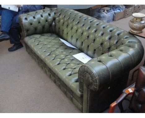 A green button leather upholstered Chesterfield settee of typical form. CONDITION REPORT: Settee seats 2 or 3 people. Heavy w