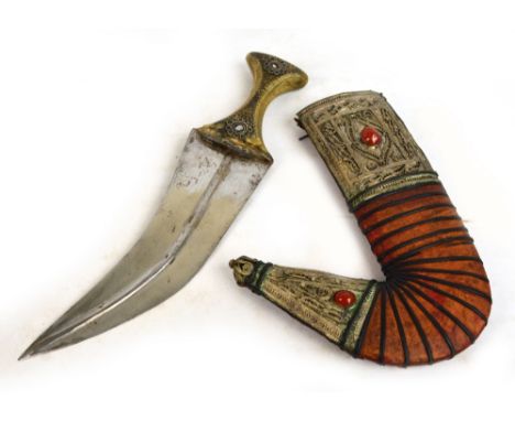 An early 20th century Jambiya dagger with horn handle set with studs and filigree decoration to one side, in leather and whit