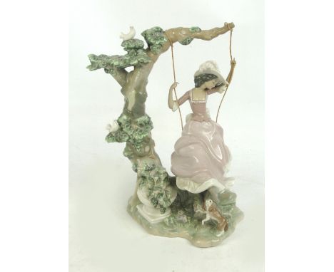 A large Lladro figure group of a girl on a swing (af).
