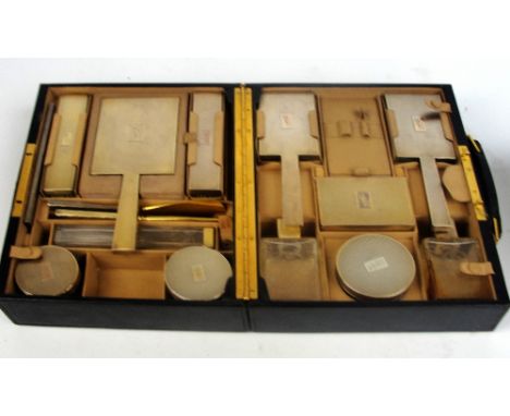 A leather cased George V hallmarked silver mounted Art Deco gentleman's vanity set comprising a hand mirror, two pairs of bru