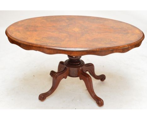 A Victorian walnut and mahogany crossbanded loo table with inlaid floral motifs on ring turned column and four cabriole legs 