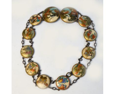 A Japanese Meiji period Satsuma belt made of twelve circular panels showing flowers, landscapes, a butterfly, and figural sce