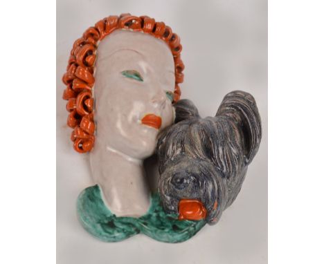 GOLDSCHEIDER; an Art Deco wall mask depicting a red haired lady and a dog, marked and impressed no.7114 to the back, height 2