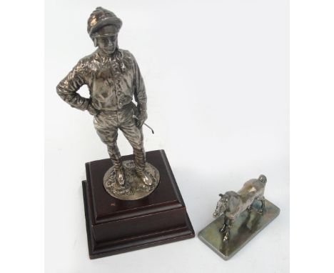 A model of a jockey standing holding his whip and mounted on a wooden plinth, height 21cm and a small desk weight modelled as