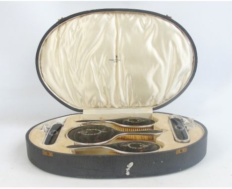 A George V hallmarked silver framed and tortoiseshell backed five piece dressing table set comprising a hand mirror, length 2