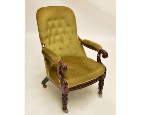An early Victorian mahogany button upholstered armchair with carved scrolls to arm rests and with ring turned and carved fron