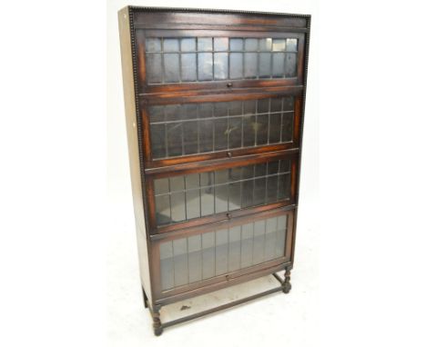 A 1920's Globe Wernicke style oak four tier bookcase with rising sliding leaded glass doors, two sections (not stacking), wid