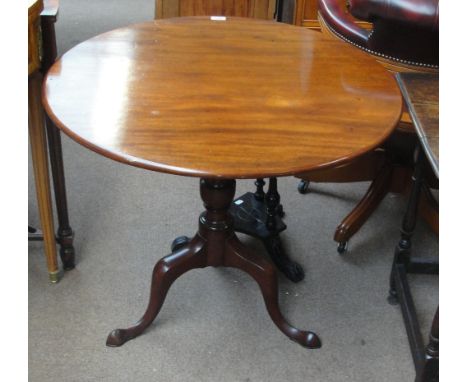 A George III mahogany tilt top occasional table, the one piece circular top above ring turned central column and three outswe