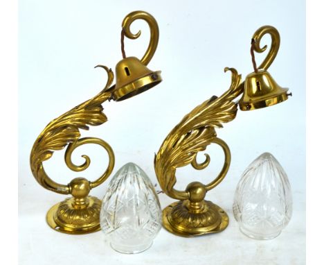 A large pair of Edwardian brass wall light fittings with foliate scroll decoration and cut glass drop ovoid shades (2).