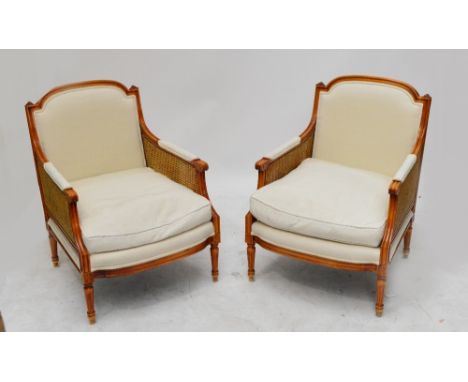 A pair of contemporary tub chairs, the padded back and loose cushions with double bergère caned sides raised on ring turned f