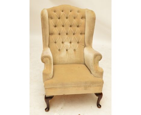 An early 20th century button upholstered wingback armchair raised on cabriole front legs.