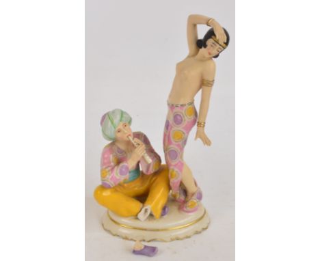 A Royal Dux figure group of an Oriental dancer and a man playing a flute, on oval base, with impressed mark to base, no.3037 