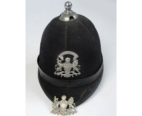 A Manchester obsolete policeman's parade helmet, and a spare badge (2).