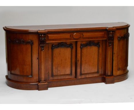 A Victorian mahogany bowfront sideboard with central frieze drawer above twin panel cupboard doors flanked by further end cup